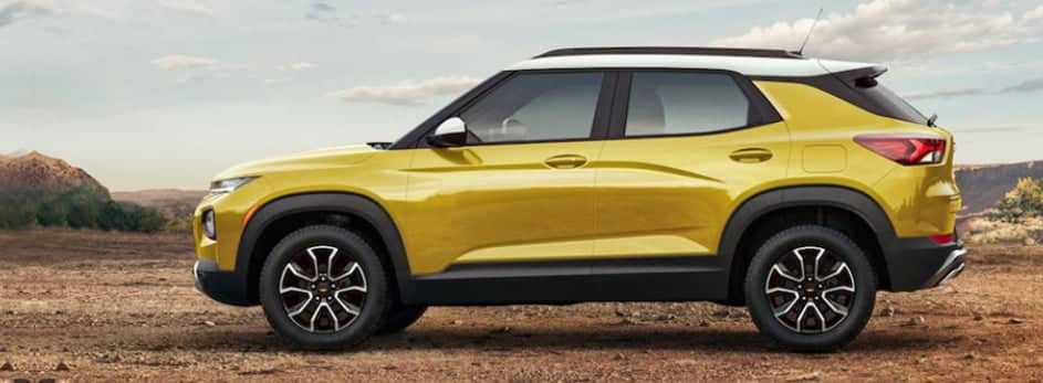 Yellow SUV with a white roof parked on a desert landscape under a clear sky.