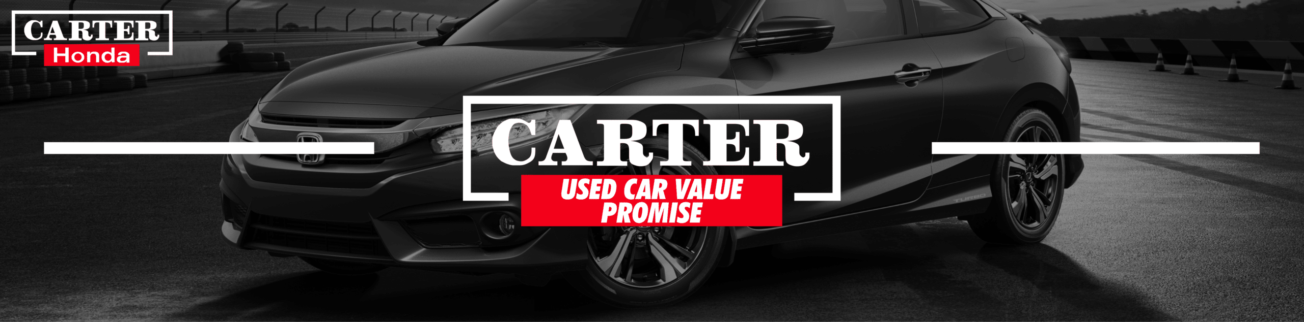 Black Honda car under "Carter Honda Used Car Value Promise" text on a racetrack.